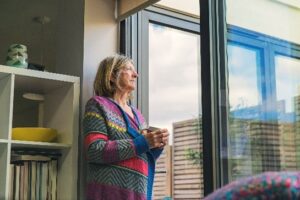 Lady looking out window representing procrastination